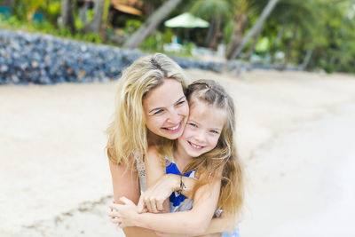 Portrait of happy mother and son at beach