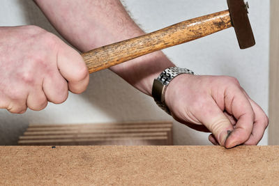 Midsection of man working on wood