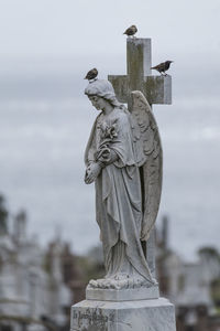 Statue of cemetery against sky