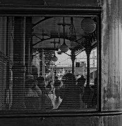 People in city seen through window