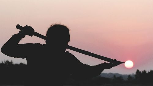 Silhouette man standing against sky during sunset