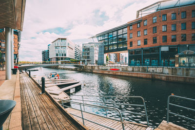 Canal amidst buildings in city against sky