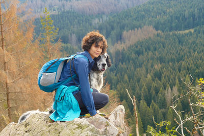 Portrait of a young woman and a dog hiking in the mountains of harz, germany