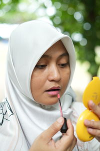 Midsection of woman holding thermometer