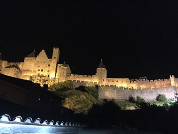 Low angle view of illuminated building against clear sky at night