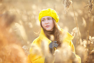 Woman looking away while standing amidst plants