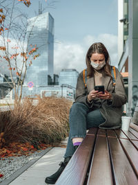 Full length of young woman using mobile phone