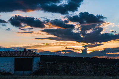 Silhouette building against sky at sunset