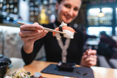 Midsection of woman holding ice cream in restaurant