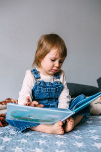 Child reads his favorite book at home. kid looks at pictures in fairy tales.