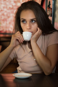 Young woman drinking coffee at cafe