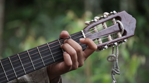 Cropped hand of person playing guitar