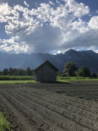 Panoramic view of a wooden hut next to a field