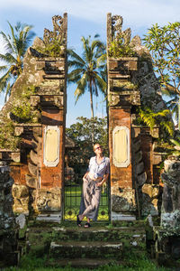 Full length of man sitting on built structure