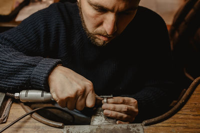 Midsection of man holding camera while sitting