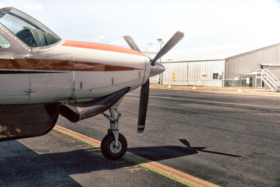 Airplane on airport runway against sky