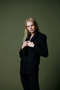 Young woman standing against black background