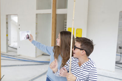 Cute sibling taking selfie at construction site