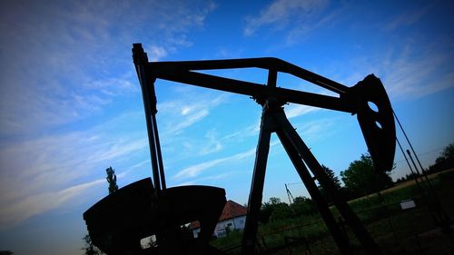 Low angle view of silhouette crane against sky during sunset