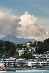 Houses by river against sky in city