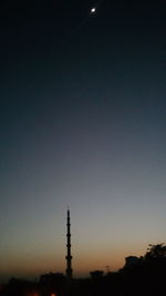 Silhouette of electricity pylon against clear sky at night