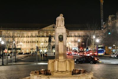 Statue in city at night