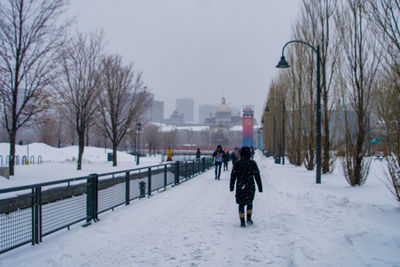 Rear view of man walking on snow covered landscape