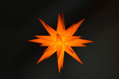 Close-up of illuminated lighting equipment against black background