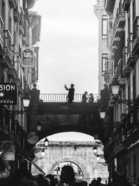 People on building in city against sky