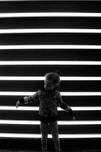 Girl standing against illuminated lights