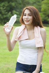 Young woman looking away while sitting in park