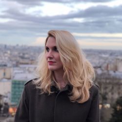 Beautiful young woman looking away against sky