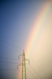 Low angle view of electricity pylon against sky during sunset