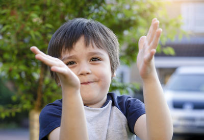 Portrait of boy applauding outdoors