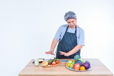Young man holding food while standing on cutting board