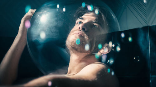 Thoughtful man alone wrapped in soap bubbles
