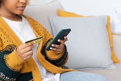 Midsection of woman using mobile phone