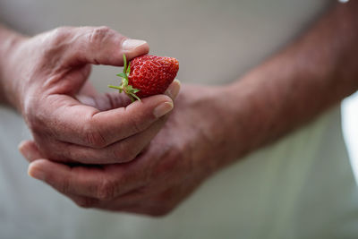 Close-up of hand holding strawberry