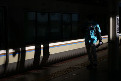 Man standing by train at railroad station platform