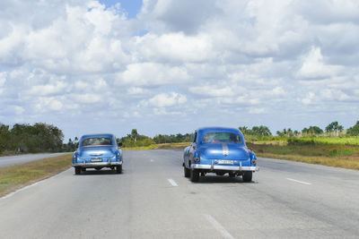 Car on road against cloudy sky