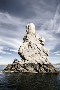 Rock formation in sea against sky