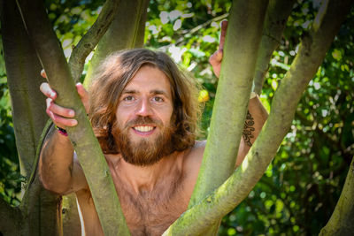 Portrait of smiling man behind à tree