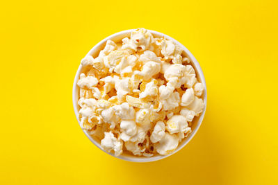 Directly above shot of popcorn against yellow background