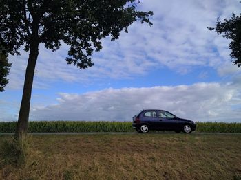 Car on field against sky