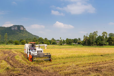 Tractor on agricultural field against sky