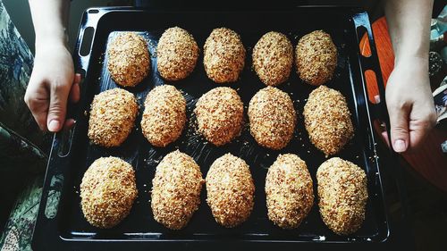 Cropped image of person holding pastries in serving tray