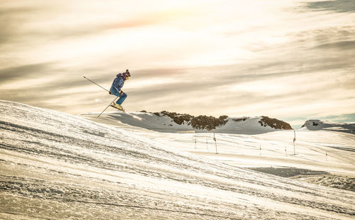 Man skiing on snow against sky