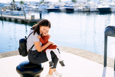 Young woman sitting on boat at lake