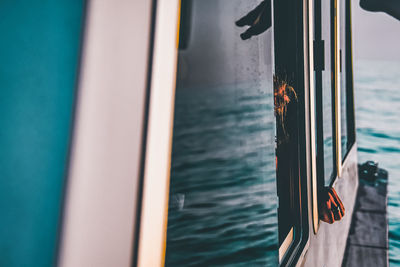 Person by sea seen through window