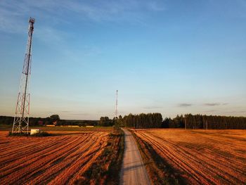 Road amidst field against sky